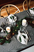DIY garland of pine and fir branches with various conifer cones on Christmas table