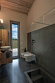 Badezimmer mit Holz-, Beton- und Glaselementen