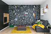 Grey sofa and wallpaper with animal motifs in TV room