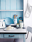 Landhausküche in blau-weiß mit Küchenutensilien und Vorräten