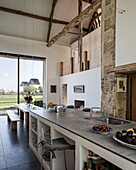 Kitchen island with limestone countertop and dining table in converted barn