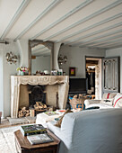Französischer Kamin und Polstermöbel mit Leinenbezug in ländlichem Wohnzimmer