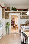 Küche im Landhausstil mit Holzverkleidung und gemusterter Tapete