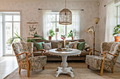 Seating furniture with flowered cover around round table in country style living room