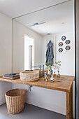 Rustikaler Waschtisch aus Holz mit Stein-Waschbecken und Spiegelwand im Badezimmer