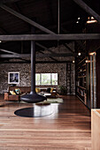 Hanging fireplace and seating area in a loft with brick wall