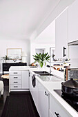 Moderne, weiße Einbauküche in offenem Wohnraum