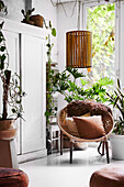Hanging lamp above the round basket hoop chair in the living room with plants