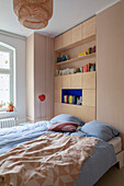 Doppelbett, dahinter Einbauschrank mit Regalen im Schlafzimmer