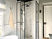 Duschbereich mit Verglasung und schwarzen Armaturen