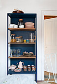 Blue open dish rack in a rustic kitchen