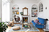 White living room with colorful accessories in a mix of styles, shelves in wall niches with round arches