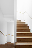 Wooden staircase in white stairwell