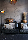 Black sofa against concrete-look wall in living room