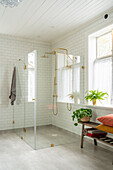 Level entry shower with glass walls and two golden shower heads