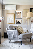 Grey armchair in front of a picture gallery in a classic living room