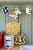 Vintage-style decorations: cow-shaped milk jug and retro cups on hooks