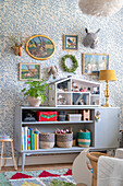 Kinderzimmer mit Vintage Sideboard, Puppenhaus, Bildern und blau-weißer Tapete