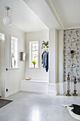 Bright hallway with white-painted wood panelling and fitted bench