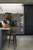 Kitchen island with breakfast bar and bar stool in the open kitchen of a loft flat