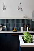 Custom kitchen units, blue wall tiles and wall-mounted lights