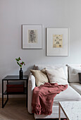 White sofa next to black side table and modern art on the wall