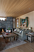Classic living room with fireplace and wood panelling in a cabin