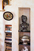 Books, bust of a woman and porcelain in tall wall niches