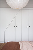 Simple fitted wardrobe with slanted section in bedroom
