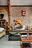 Two sofas and coffee table in an open living room with an exposed brick wall