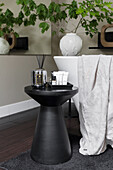 Black stool with bathroom accessories next to freestanding bathtub