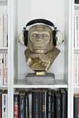 Gold-coloured gorilla bust used as headphone stand on shelf