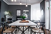 Klassikerstühle um Esstisch mit Marmorplatte im Zimmer mit grauen Wänden