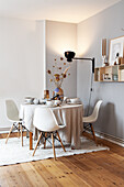 Breakfast table with linen cloth and classic chairs in corner of room
