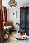 Jungenzimmer mit Schrank im Industriedesign, Bett und Terrakotta-Farbakzenten