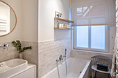 Small, white bathroom with sink in niche and half-height tiled wall