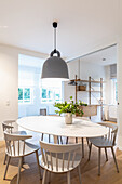 Spoke-back chairs around oval, Scandinavian-style dining table