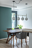 Wooden table with upholstered shell chairs in front of blue wall in dining area