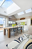 Kitchen and dining area with wooden table and classic chairs under skylight