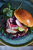 Grilled pork and red coleslaw sandwich on ceramic plate