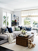 Grey upholstered sofa with throw pillows and rattan coffee table in the living room