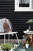 Metallstuhl und Holzblock als Beistelltisch auf der Terrasse