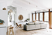 Modern open living room in white with sloped ceiling and wall of windows