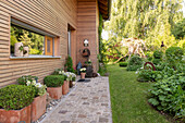 Paved path with planters in front of wooden house