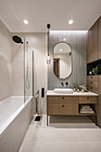 Elegantes Badezimmer mit Waschtisch, Badewanne und Regendusche