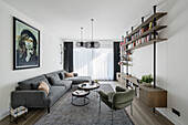 Grey corner sofa, coffee table set, armchair and bookshelves-sideboard combination in living room