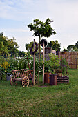 Rural arrangement with ladder wagon and earthenware pots at the perennial bed with daisies