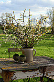 Kirschblütenstrauß auf altem Holztisch