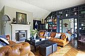 Cognac colored leather sofas, coffee table, fireplace, and floor-to-ceiling built-in bookcase in the living room