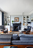 Blick über Sofa auf Klassiker Lounge Chair und Sessel vor Kamin